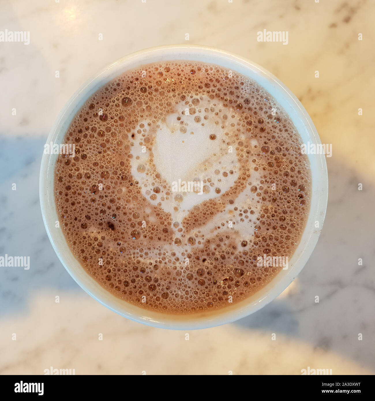 Cioccolata calda (latte) arte nella forma di un fiore bianco. Foto Stock