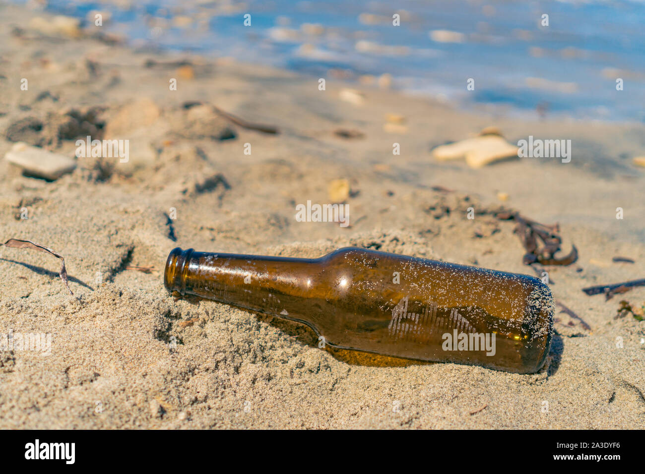 Bottiglia vuota viene abbandonato sulla spiaggia durante il periodo estivo la bottiglia di birra dovrebbero essere riciclati. Foto Stock