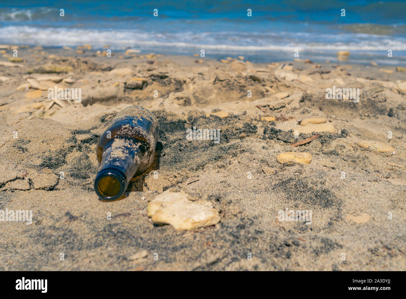 Una bottiglia di vetro è diventato il cestino dopo che esso è stato lasciato sulla spiaggia invece di essere riciclati bottiglia Foto Stock