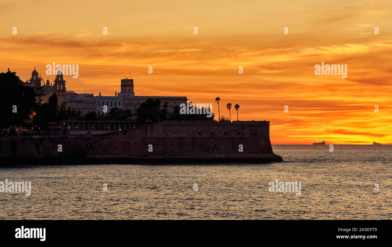 Fortezza di Candelaria Silhouette al tramonto contro il cielo arancione cadice andalusia Foto Stock