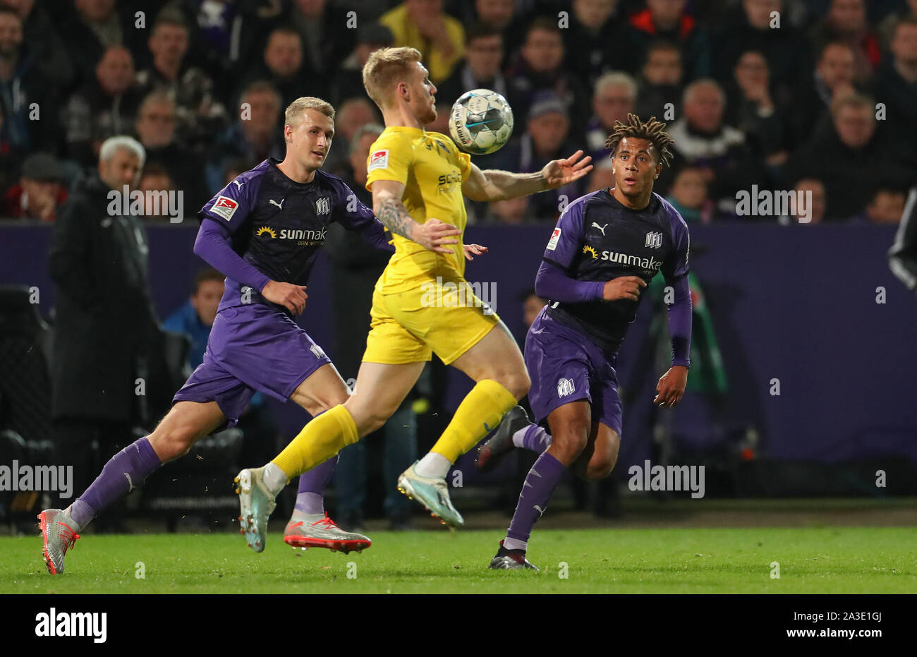 07 ottobre 2019, Bassa Sassonia, Osnabrück: Calcio: Seconda Bundesliga, VfL Osnabrück - Arminia Bielefeld, 9 giornata nello stadio di Bremer Brücke. Osnabrück's Lukas Gugganig (l) ed Etienne Amenyido (r) nella lotta per la sfera con Andreas Voglsammer (M) da Bielefeld. Foto: Friso Gentsch/dpa - NOTA IMPORTANTE: In conformità con i requisiti del DFL Deutsche Fußball Liga o la DFB Deutscher Fußball-Bund, è vietato utilizzare o hanno utilizzato fotografie scattate allo stadio e/o la partita in forma di sequenza di immagini e/o video-come sequenze di foto. Foto Stock