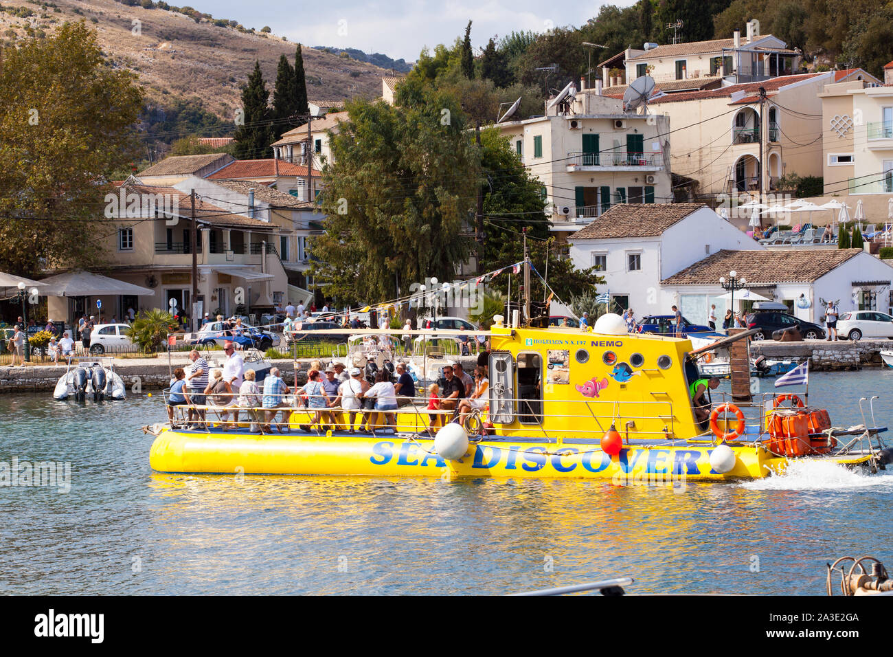 Le persone e i turisti a bordo di una gita in barca nel porto al Greek holiday resort di Kassiopi Corfù Grecia Foto Stock