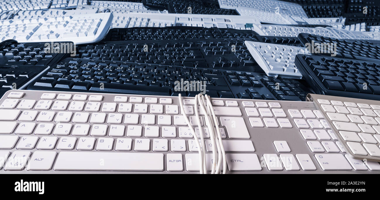 Sfondo panoramico delle tastiere dei computer e i pulsanti di dettaglio delle texture. Vista laterale della pila di hardware per scrivere. La digitalizzazione dei dati, la burocrazia. Rifiuti elettronici. Foto Stock