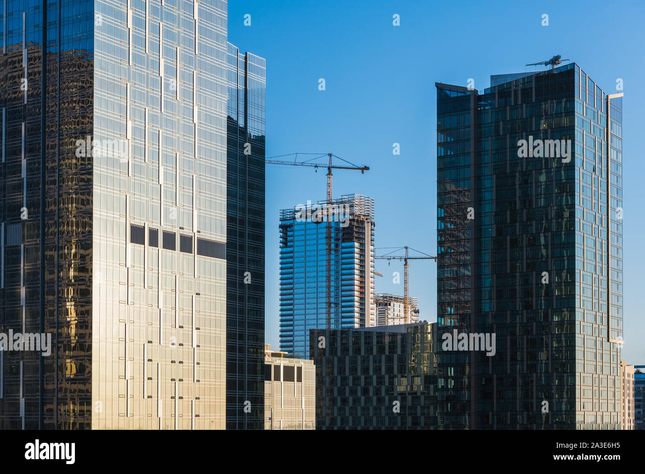 Larga scala di immobili commerciali nello sviluppo della moderna in vetro e acciaio grattacieli e gru con nuova costruzione Foto Stock