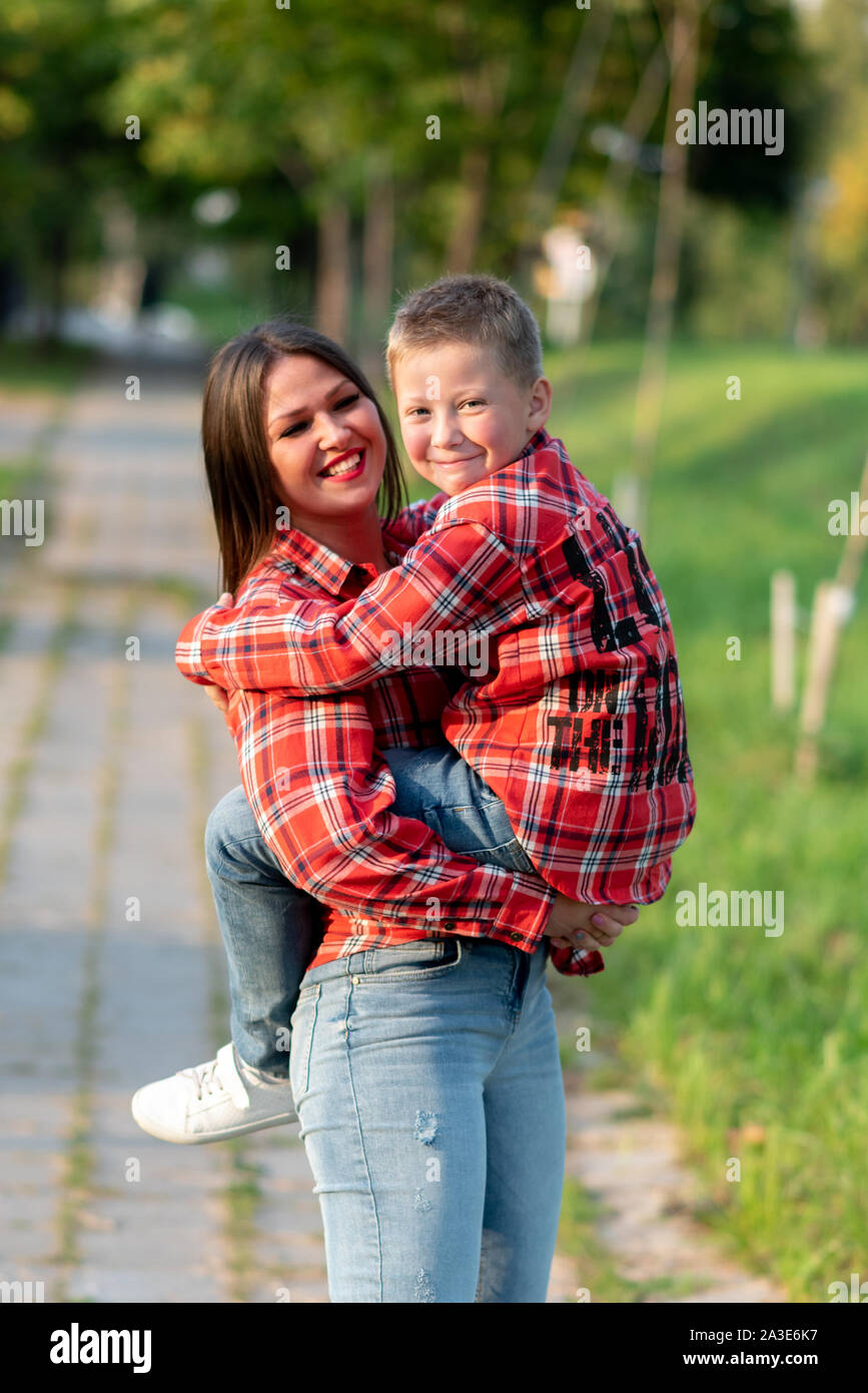 Mom, sorridente largamente, mantiene il suo figlio nelle sue braccia. Foto Stock