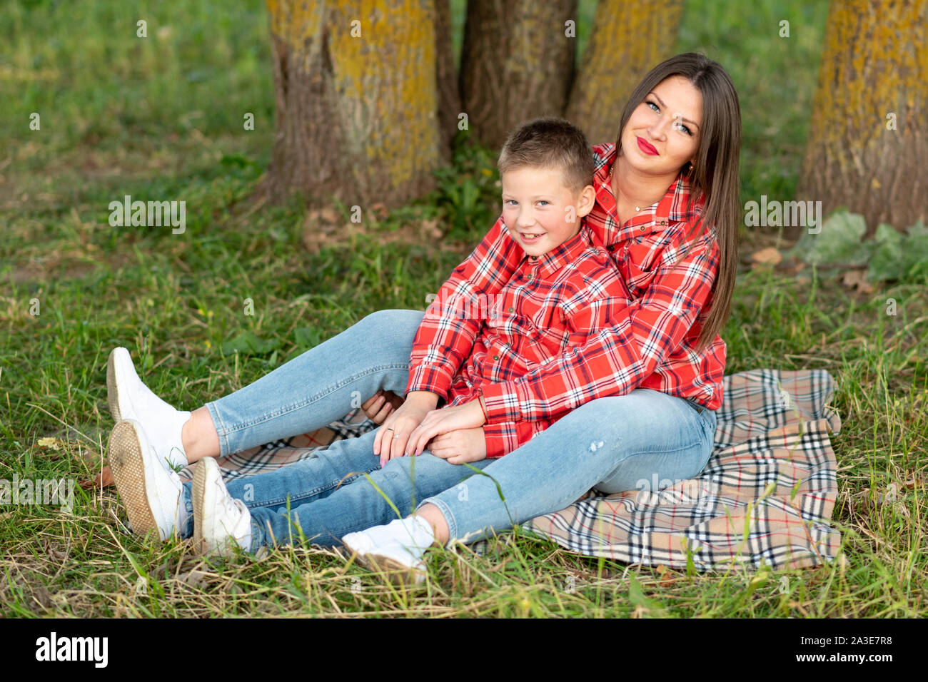 Madre e figlio, disteso sul copriletto, abbraccio e sorriso. Foto Stock