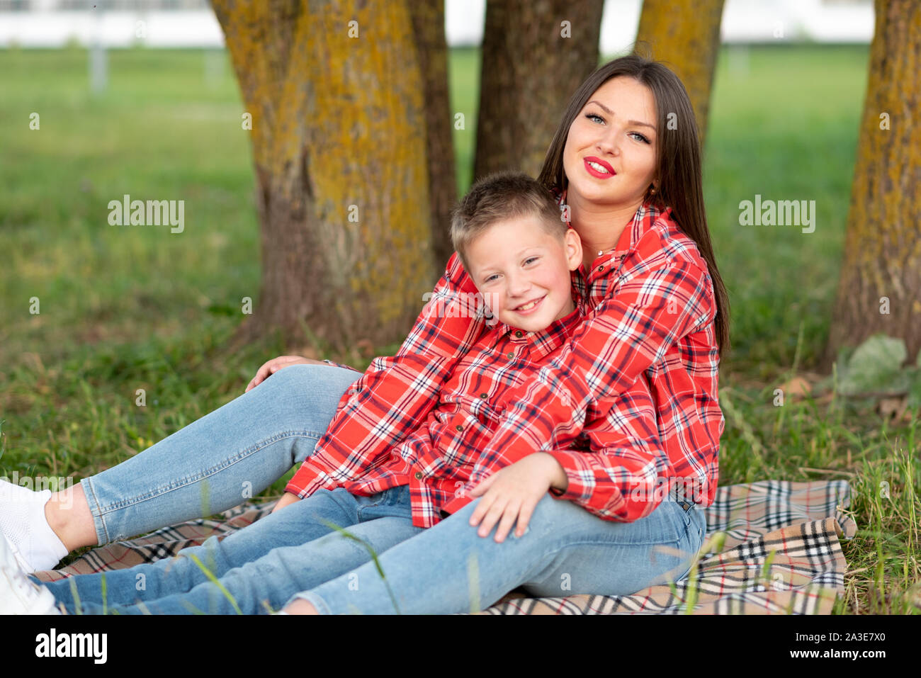 Madre e figlio, disteso sul copriletto, abbraccio e sorriso. Foto Stock