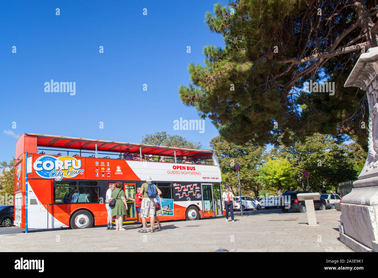 Persone di salire e scendere una gita open top hop on hop off double decker bus nella città greca di Corfu Grecia Foto Stock