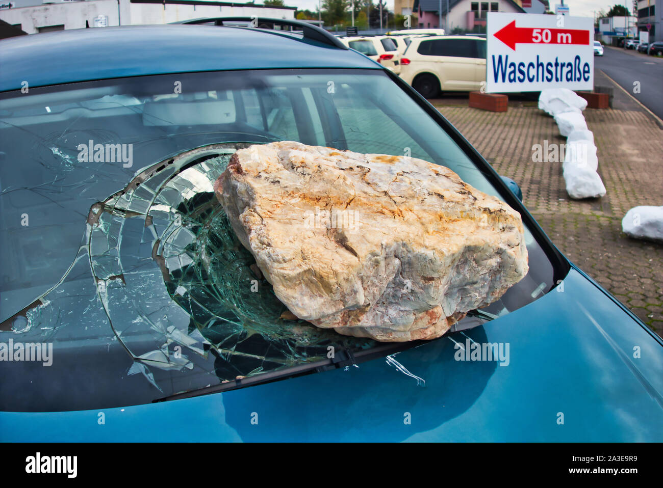 Le cadute di massi, eye-catcher di un parabrezza di automobile repair shop. Foto Stock