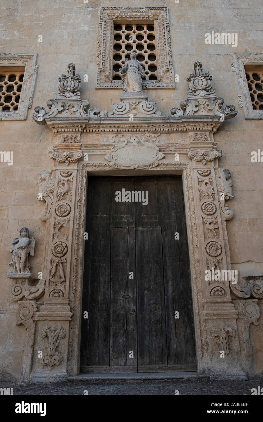 Melpignano. Città greca, vista l'antica porta del palazzo vicino alla cattedrale. La simmetria della facciata in pietra leccese lavorato con motivi floreali e simbolo Foto Stock