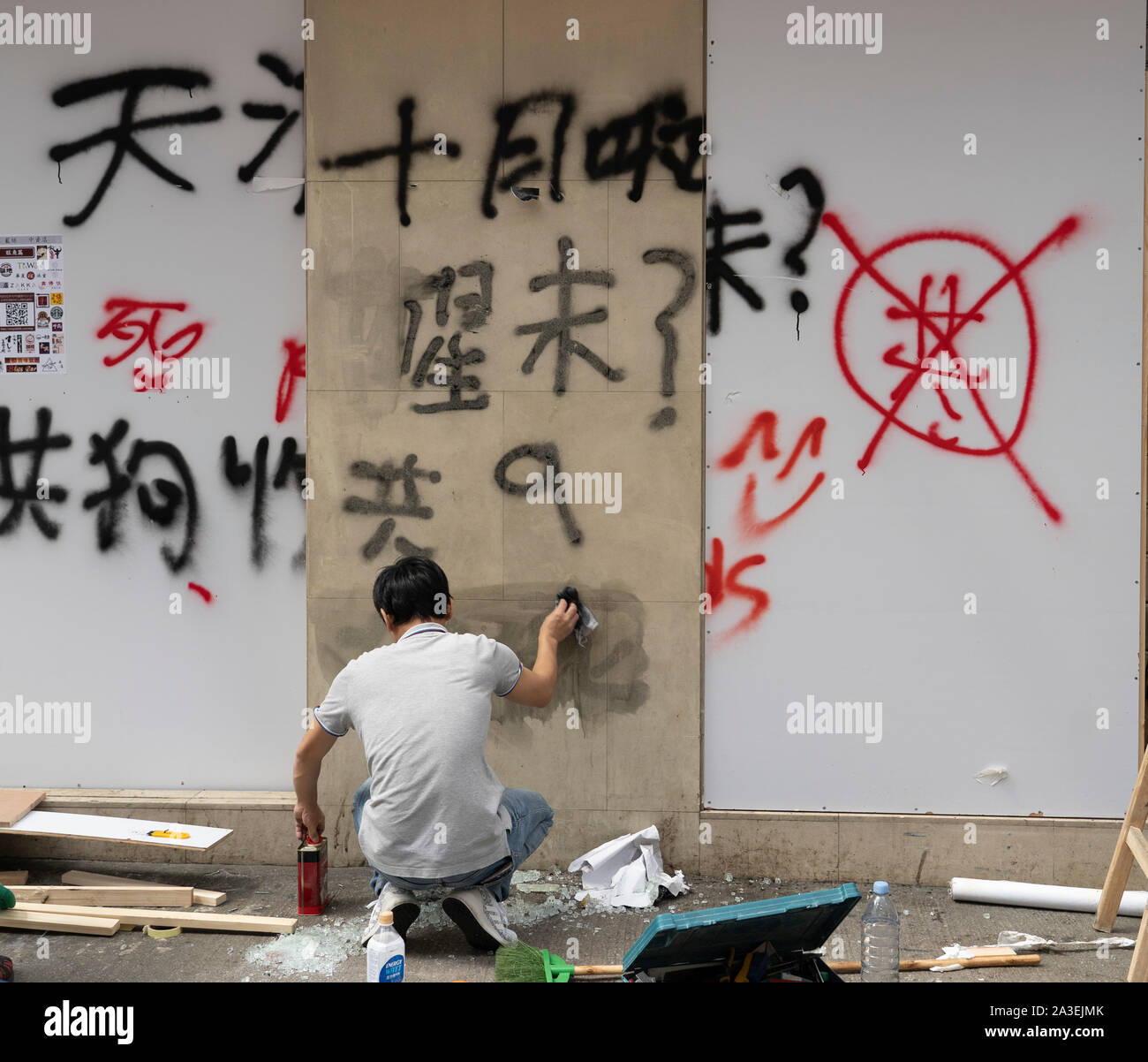 Kowloon, Hong Kong, Cina. 7 Ottobre, 2019. Dopo una notte di violenti scontri tra la polizia e la pro-democrazia manifestanti in MongKok e stazione YauMaTei in Kowloon, molti MTR, stazioni ferroviarie e che cosa sono il pensiero di essere pro-Pechino franchise business sono stati soggetto ad atti vandalici. Lavoratore rimozione di graffiti al cinese di proprietà di banca. Foto Stock