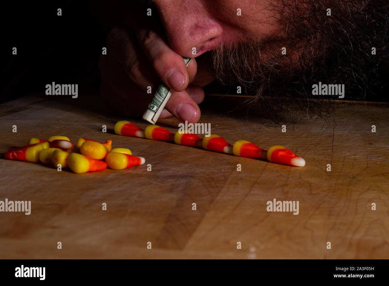 L'uomo sbuffare candy corn durante il tempo di halloween Foto Stock