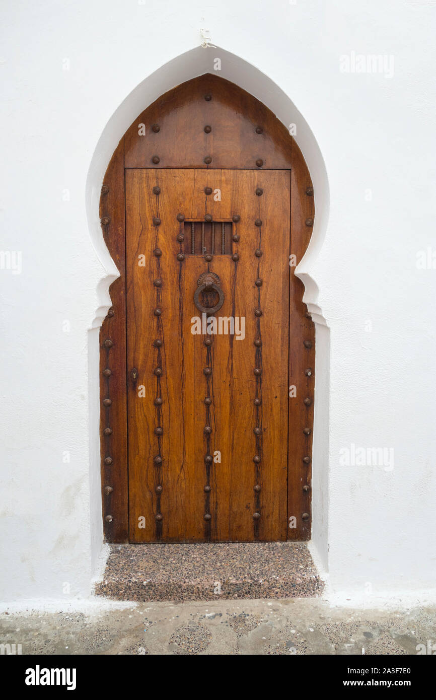 Vecchia porta di legno con decorazione in ottone nella Medina di Asilah, Marocco Foto Stock