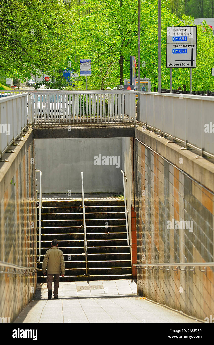 Uomo che cammina nel sottopassaggio in Burnley town center Foto Stock