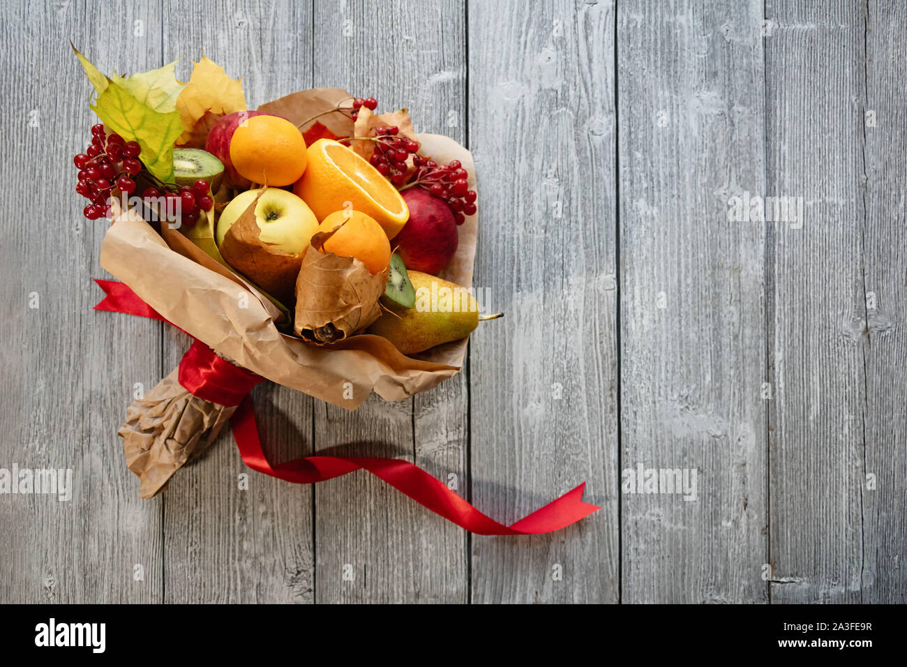 Una deliziosa e bel bouquet di frutti. Nozze d'autunno. La sposa il bouquet. Sfondo di legno. Foto Stock