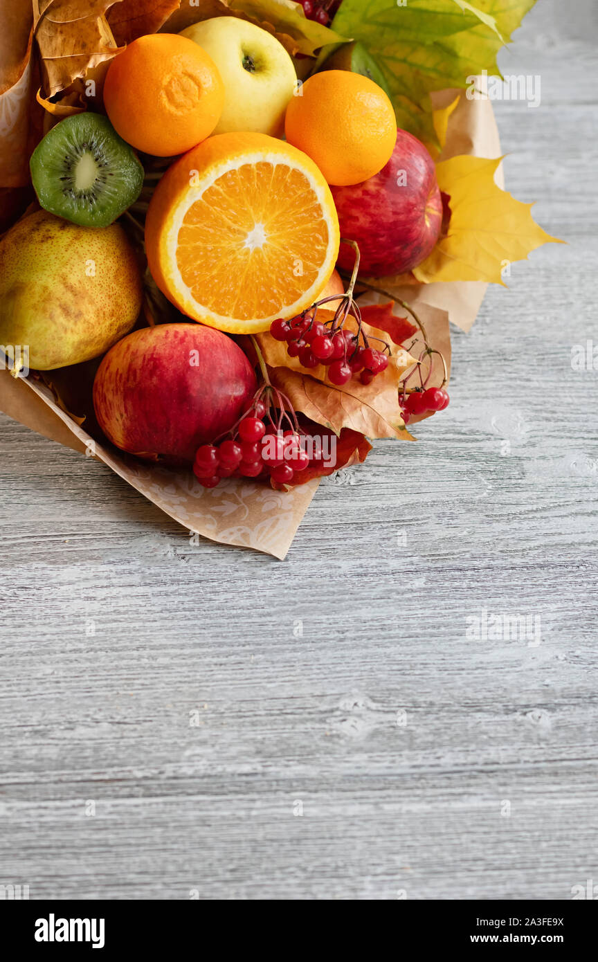 Un delizioso profumo di frutti maturi. Concetto di raccolto. Composizione d'autunno. Copia dello spazio. Grigio sfondo di legno. Foto Stock