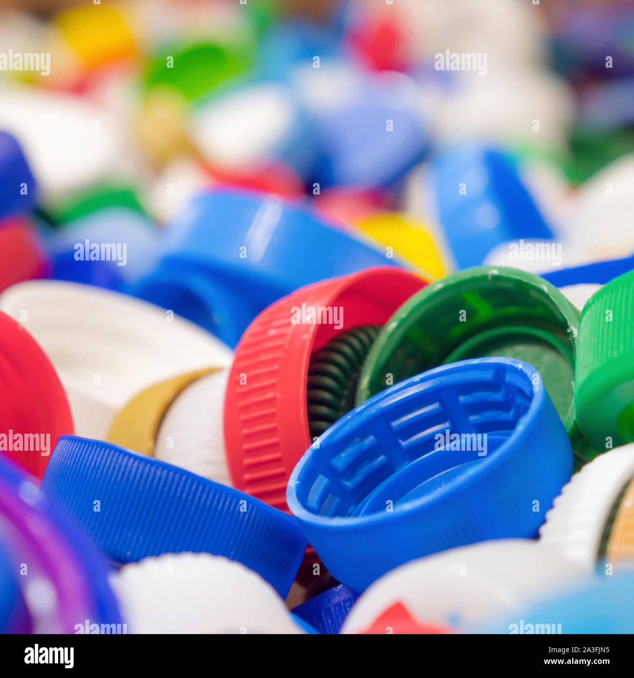 La bottiglia di plastica tappi di diversi colori. Sullo sfondo di un sacco di tappi in plastica. Gruppo di oggetti per il design. Il riciclaggio dei rifiuti Immondizia di plastica dello sfondo. Concetto di riciclaggio. Il danno per la natura. Foto Stock