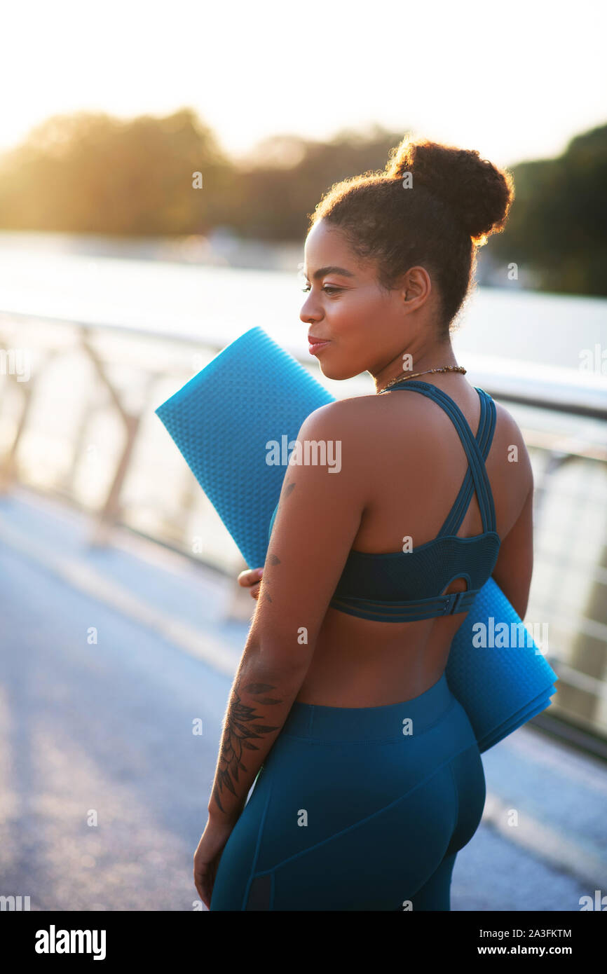 Donna che indossa gambali e breve top pronto per l'allenamento Foto Stock