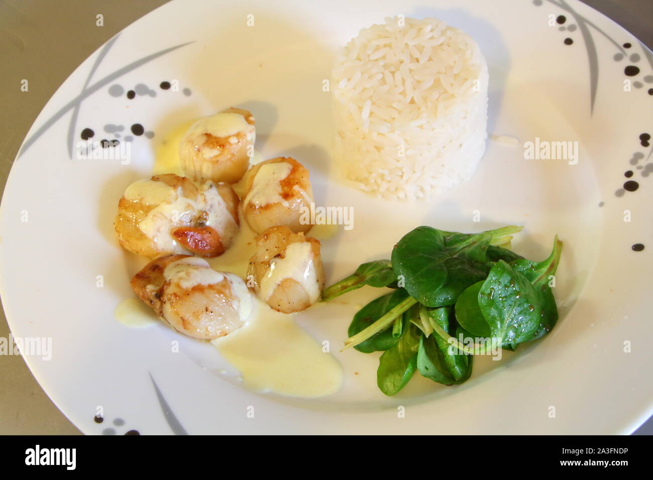 Piastra di capesante grigliate con il riso e la valeriana Foto Stock