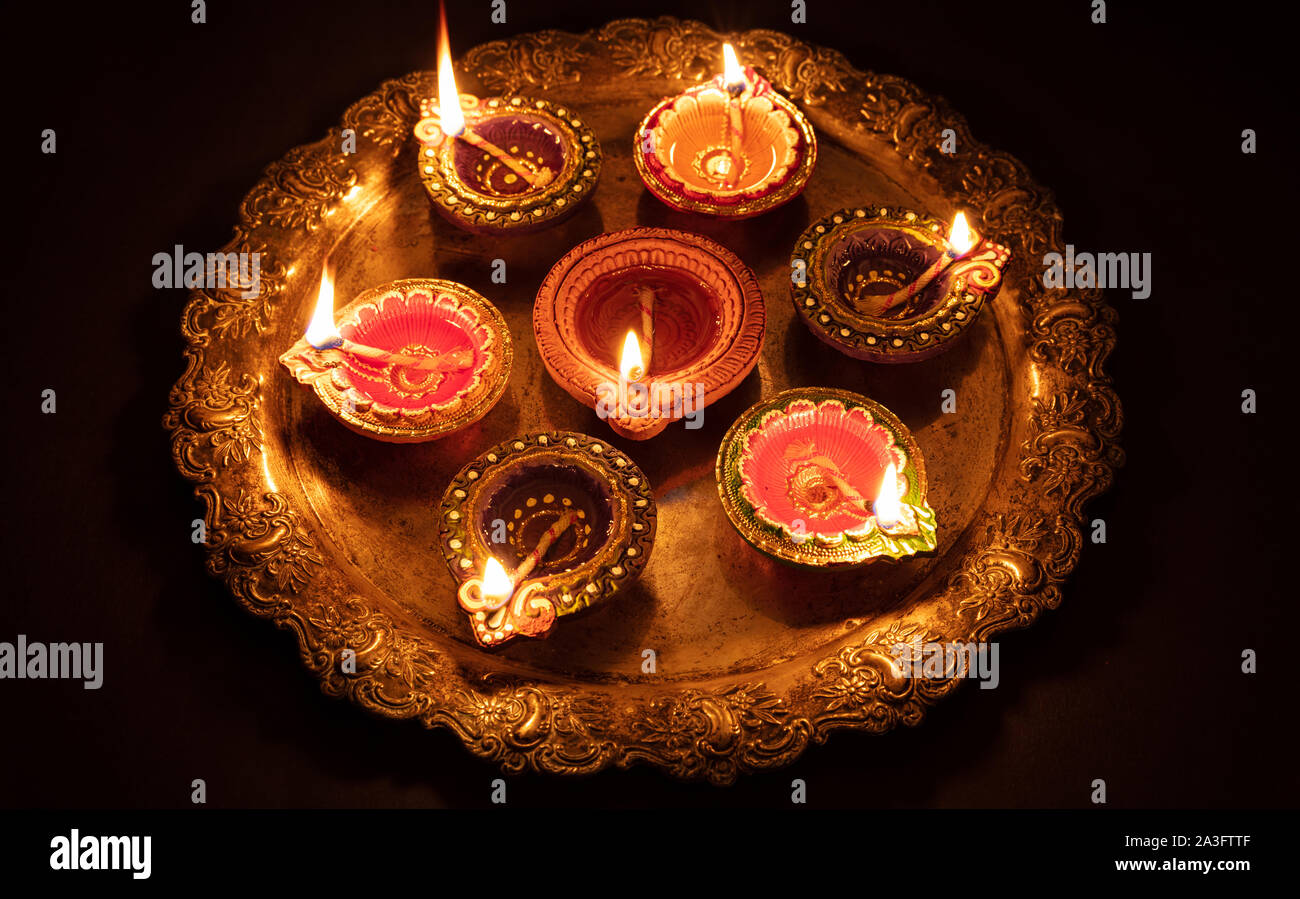 Felice Diwali. Clay diya candele accese in Dipavali, festival indù delle luci. Tradizionali lampade a olio su sfondo scuro Foto Stock