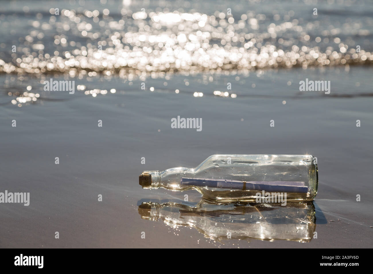 Bottiglia con un messaggio sulla spiaggia Foto Stock