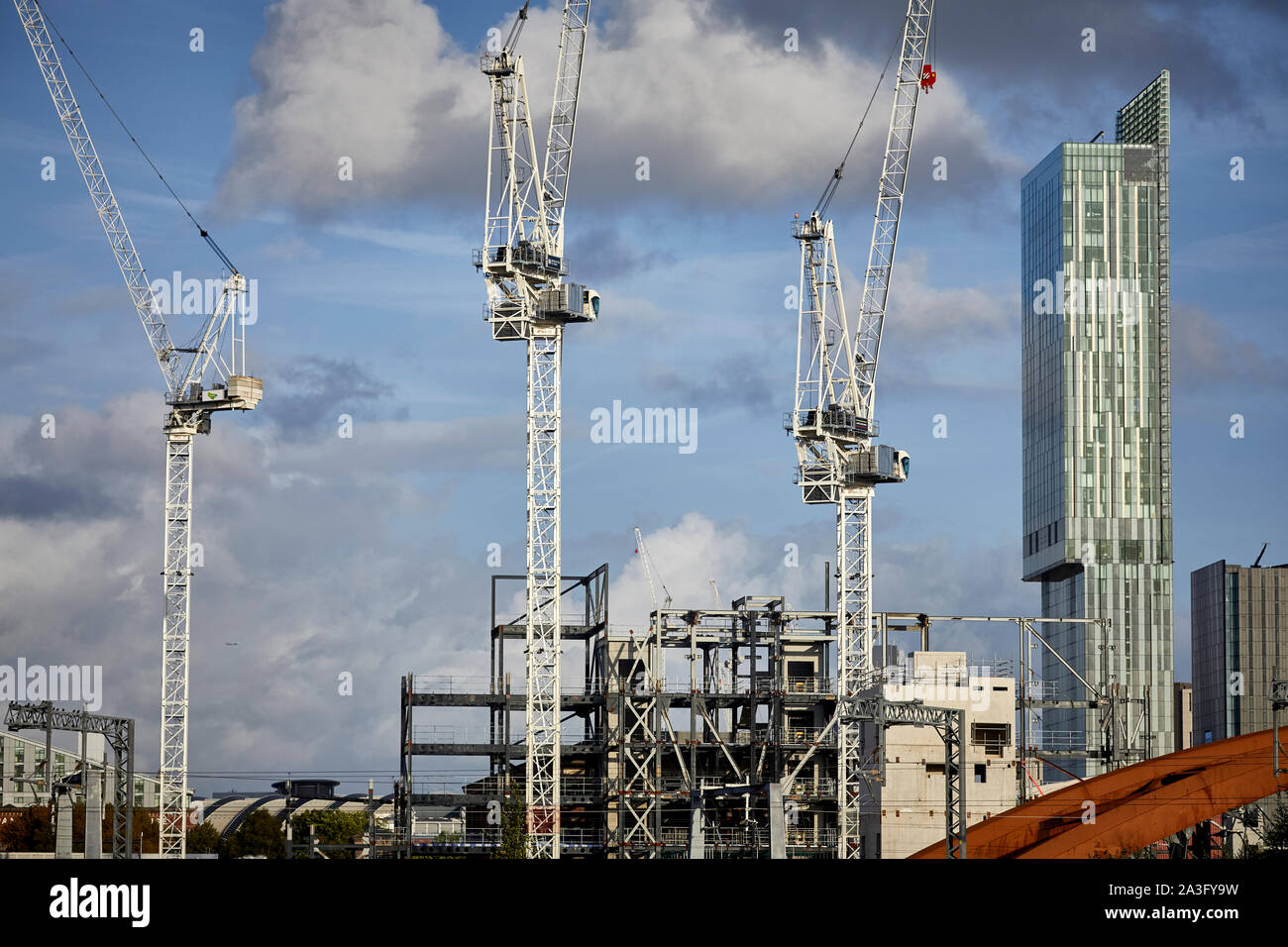 Il centro città di Manchester skyline con gru a torre e landmark Beetham Tower presso San Giovanni del quartiere della vecchia Granada Studio site Foto Stock