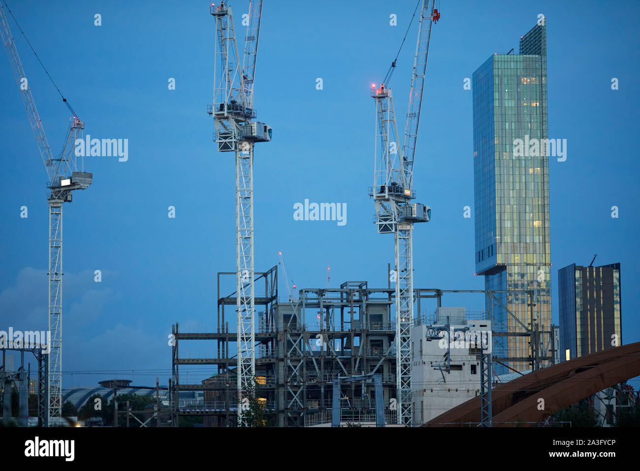 Il centro città di Manchester skyline con gru a torre e landmark Beetham Tower presso San Giovanni del quartiere della vecchia Granada Studio site Foto Stock