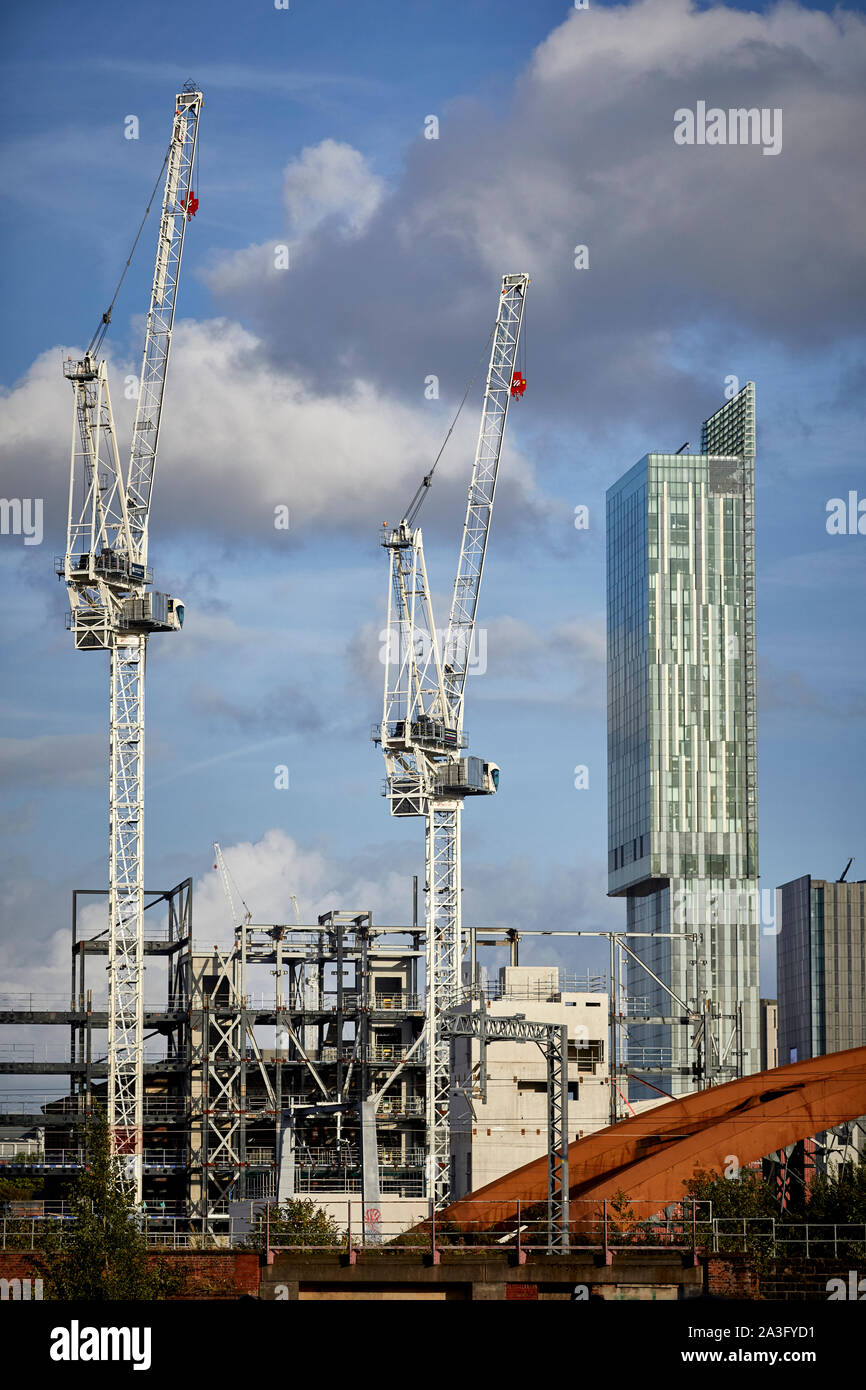Il centro città di Manchester skyline con gru a torre e landmark Beetham Tower presso San Giovanni del quartiere della vecchia Granada Studio site Foto Stock