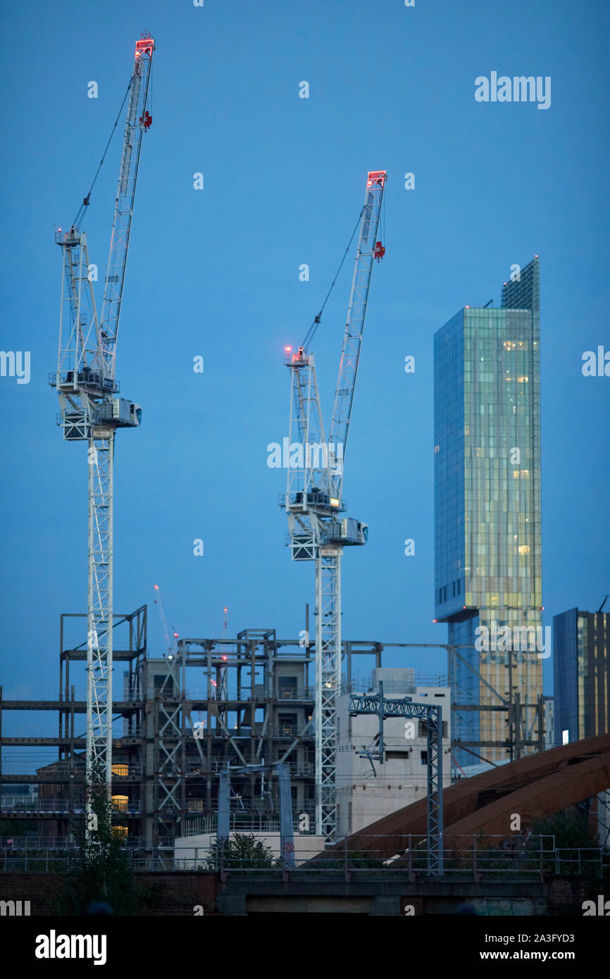 Il centro città di Manchester skyline con gru a torre e landmark Beetham Tower presso San Giovanni del quartiere della vecchia Granada Studio site Foto Stock