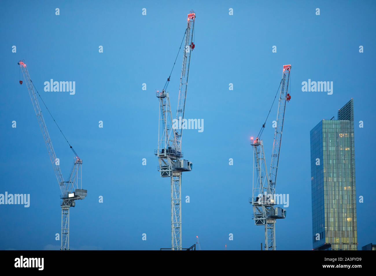 Il centro città di Manchester skyline con gru a torre e landmark Beetham Tower presso San Giovanni del quartiere della vecchia Granada Studio site Foto Stock