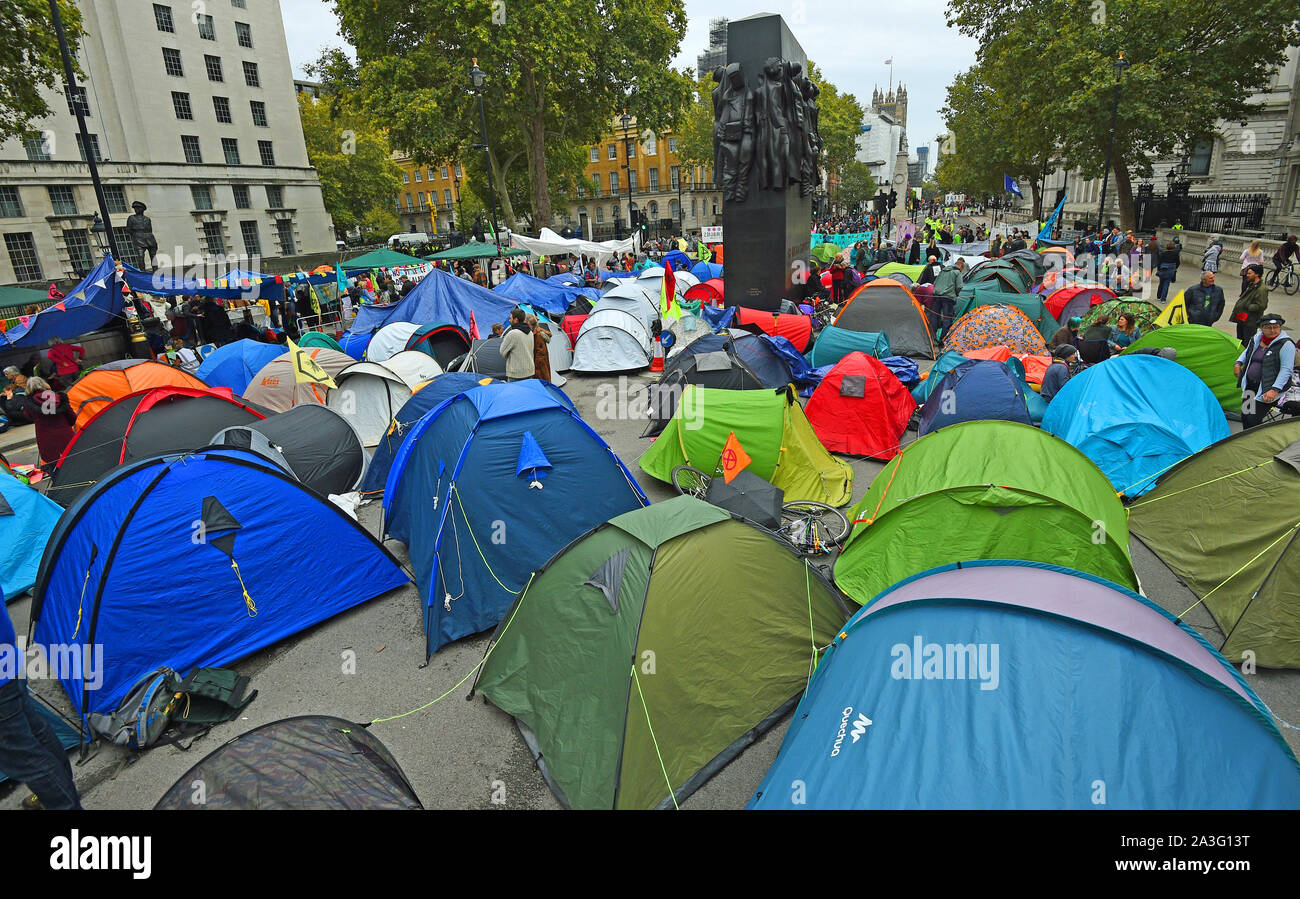 La Ribellione di estinzione (XR) manifestanti camp in tende intorno al Monumento per le donne della II Guerra Mondiale su Whitehall a Westminster, nel centro di Londra, come il cambiamento climatico protesta continua in un secondo giorno. Foto Stock