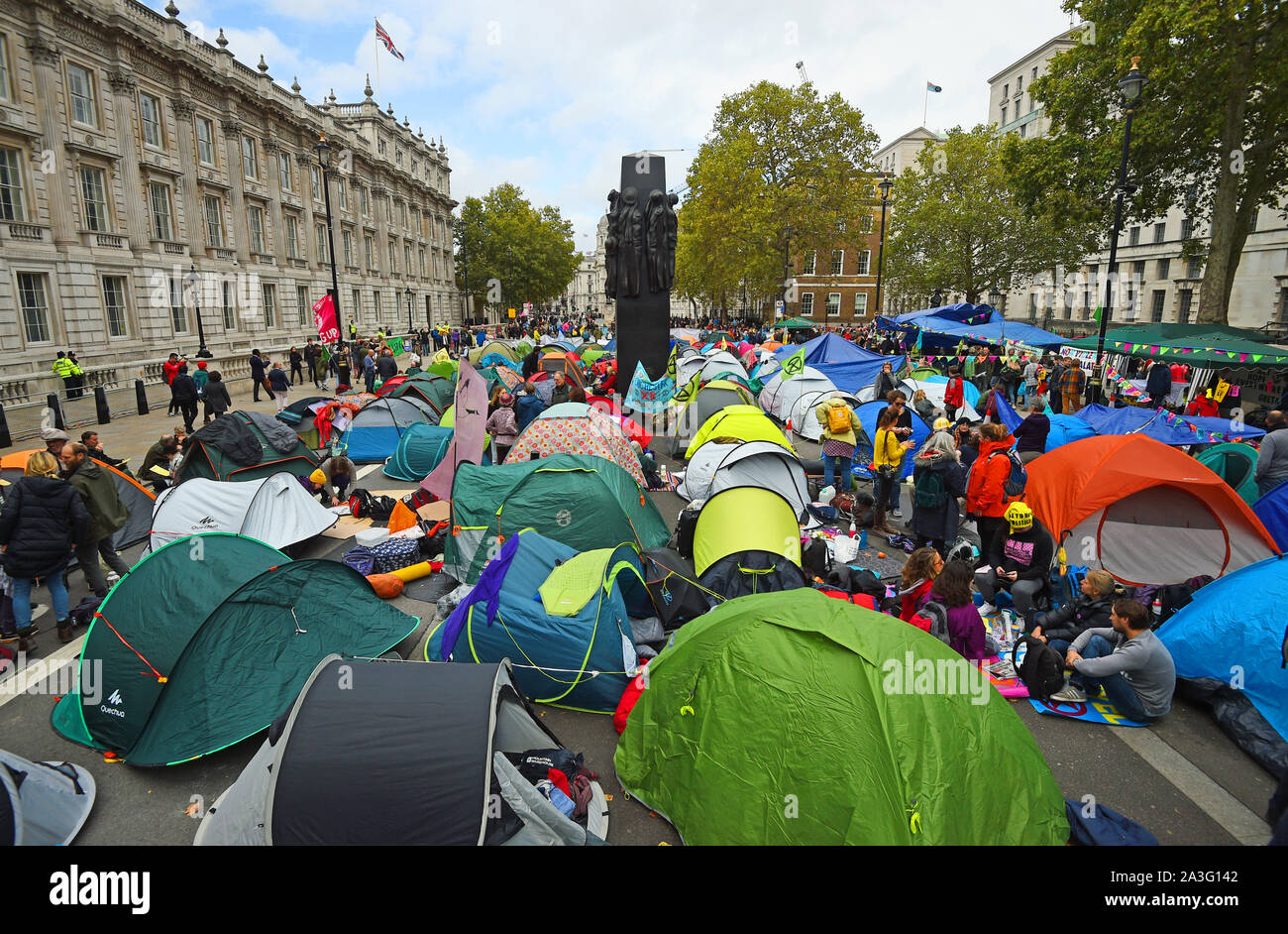 La Ribellione di estinzione (XR) manifestanti camp in tende intorno al Monumento per le donne della II Guerra Mondiale su Whitehall a Westminster, nel centro di Londra, come il cambiamento climatico protesta continua in un secondo giorno. Foto Stock