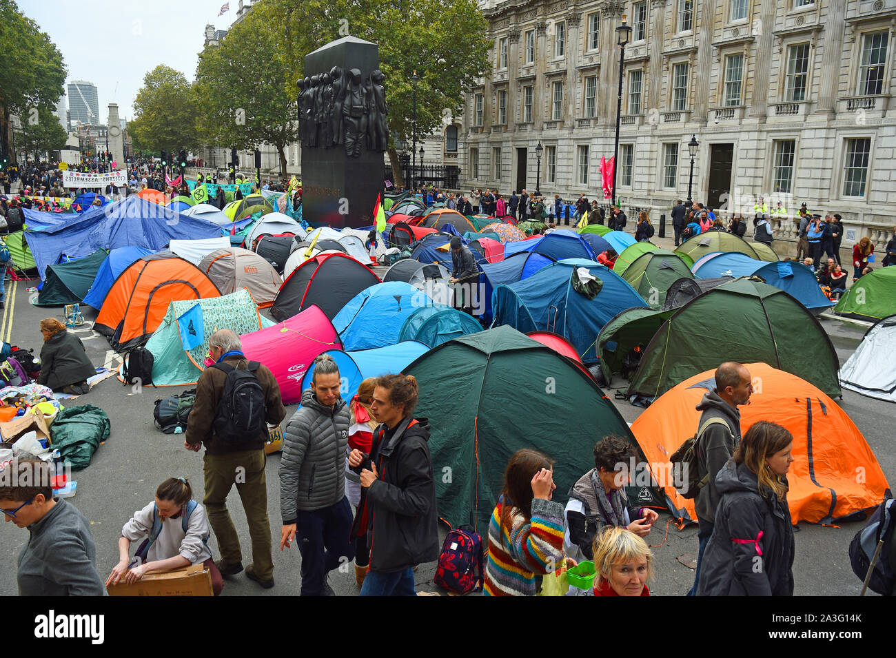 La Ribellione di estinzione (XR) manifestanti camp in tende intorno al Monumento per le donne della II Guerra Mondiale su Whitehall a Westminster, nel centro di Londra, come il cambiamento climatico protesta continua in un secondo giorno. Foto Stock