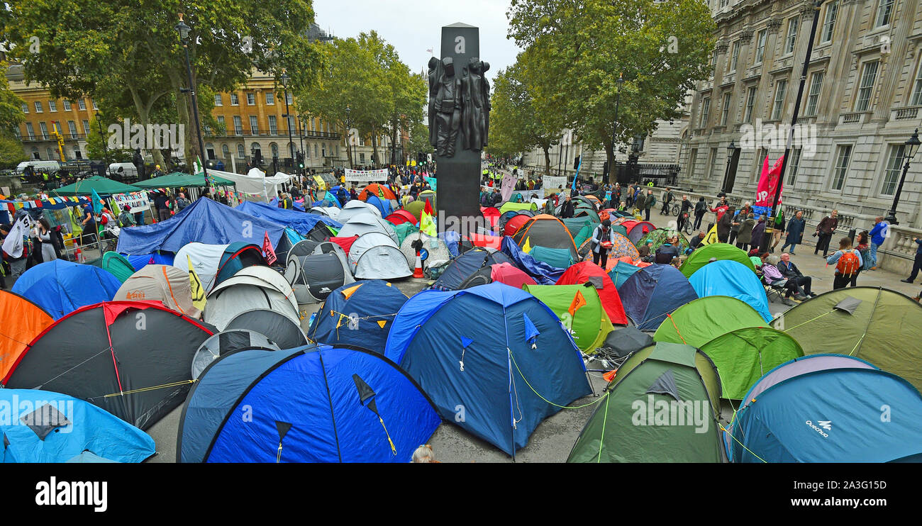 La Ribellione di estinzione (XR) manifestanti camp in tende intorno al Monumento per le donne della II Guerra Mondiale su Whitehall a Westminster, nel centro di Londra, come il cambiamento climatico protesta continua in un secondo giorno. Foto Stock