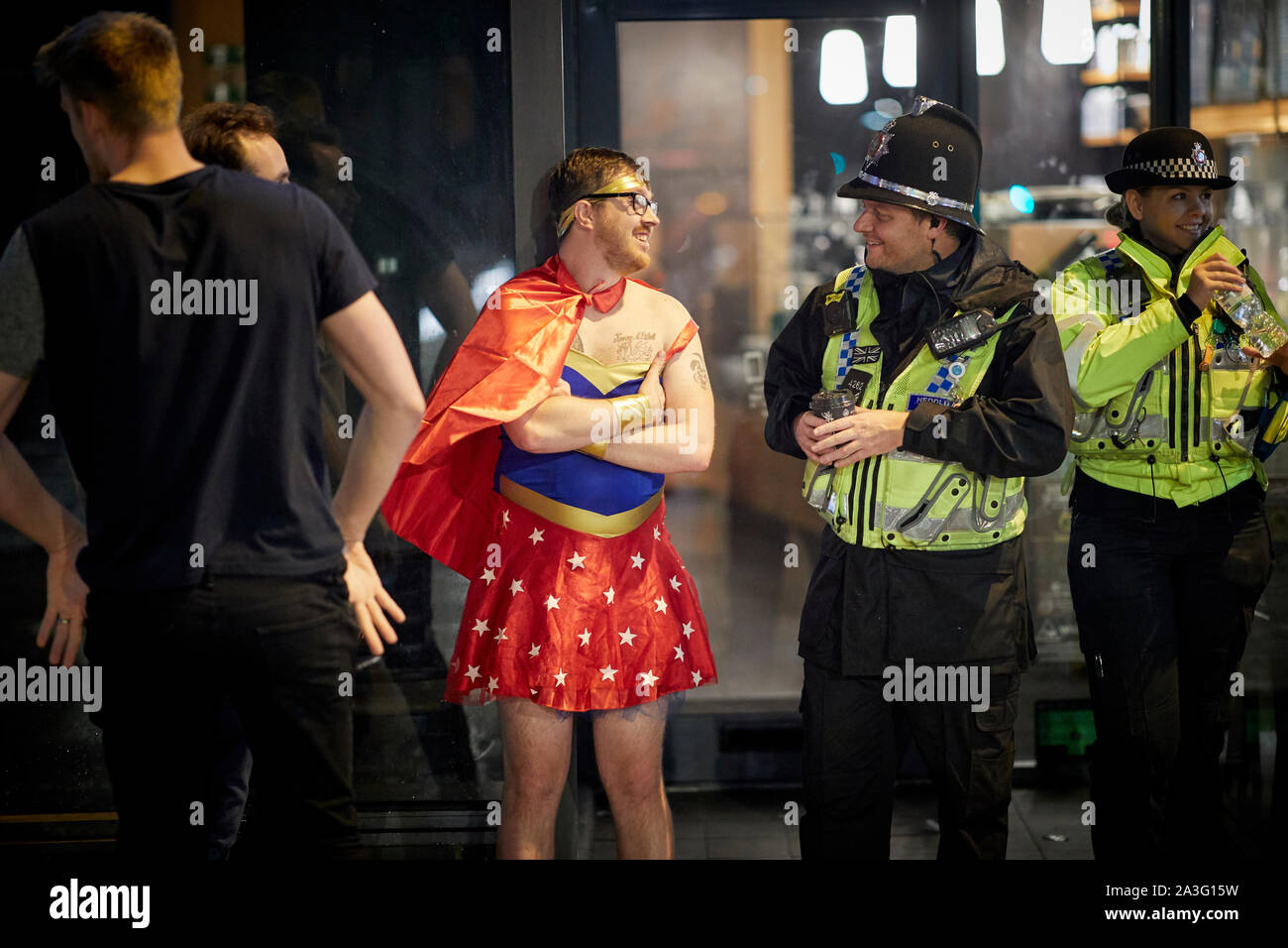 Cardiff Wales, uomo vestito in abiti fantasiosi come Wonderwoman a chiacchierare con la polizia Foto Stock
