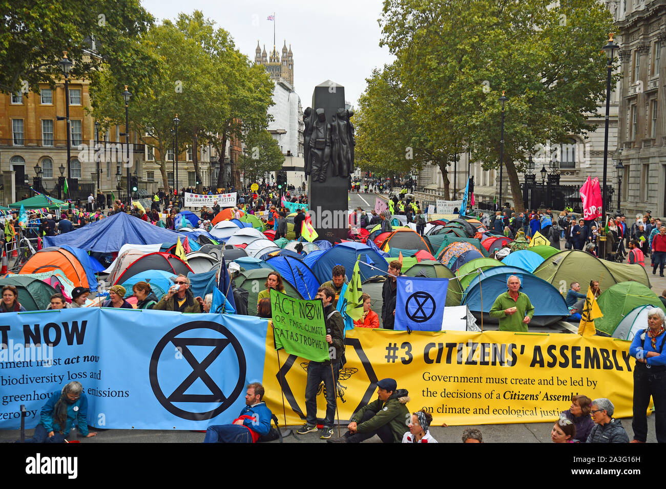 La Ribellione di estinzione (XR) manifestanti camp in tende intorno al Monumento per le donne della II Guerra Mondiale su Whitehall a Westminster, nel centro di Londra, come il cambiamento climatico protesta continua in un secondo giorno. Foto Stock