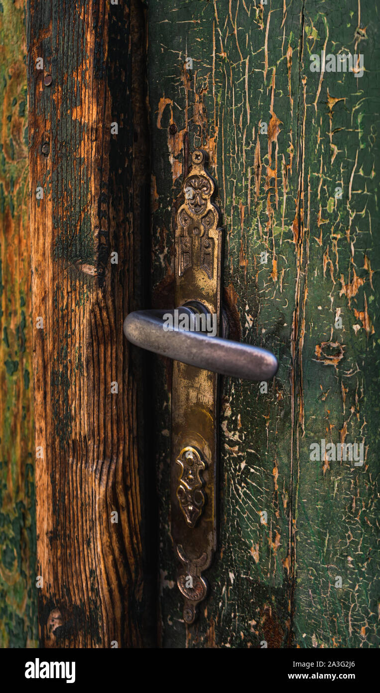 Primo piano sul vecchio, di legno porta verde con fisso vintage maniglia della porta Foto Stock