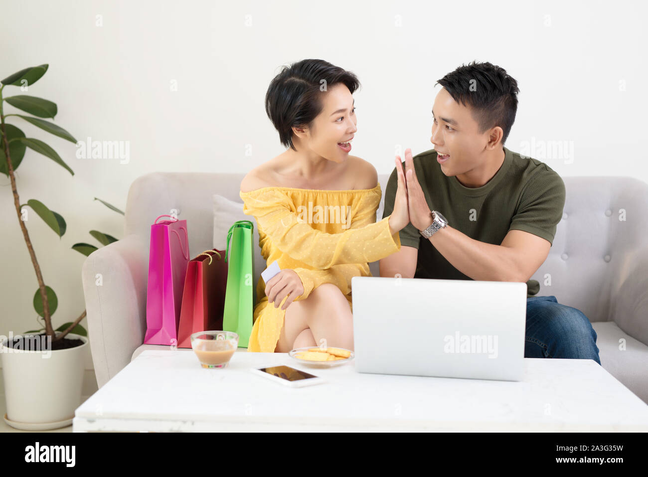 Emozionato Asian giovane utilizzando laptop per l'acquisto online con un buon affare. Foto Stock