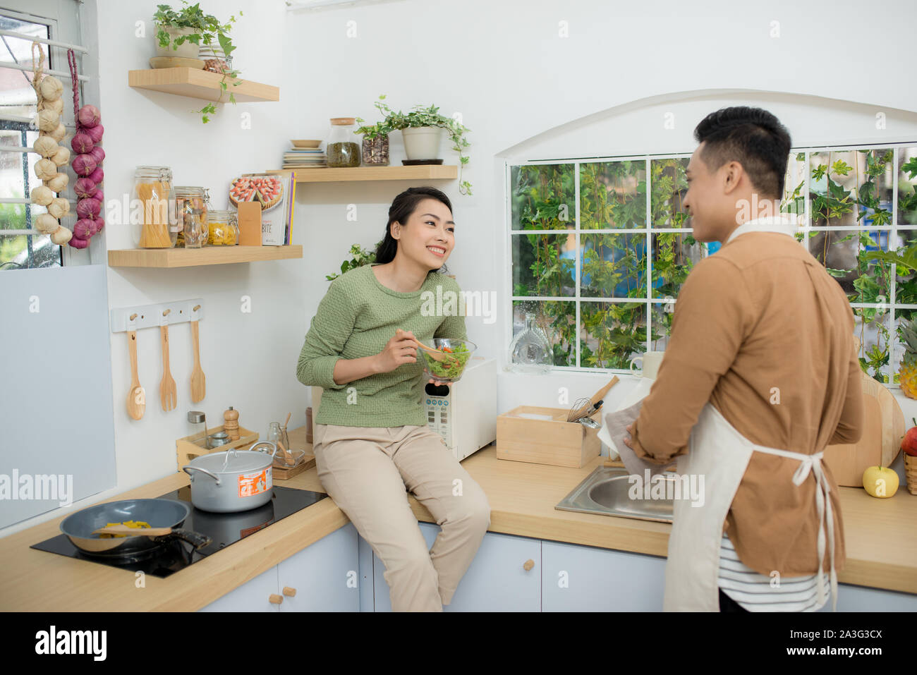 Coppia asiatica di mangiare la prima colazione al mattino presto in cucina e di avere un buon tempo. Foto Stock