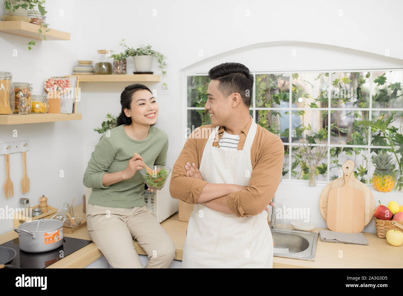 Bella coppia Giovane sta parlando, guardando ogni altro in cucina Foto Stock