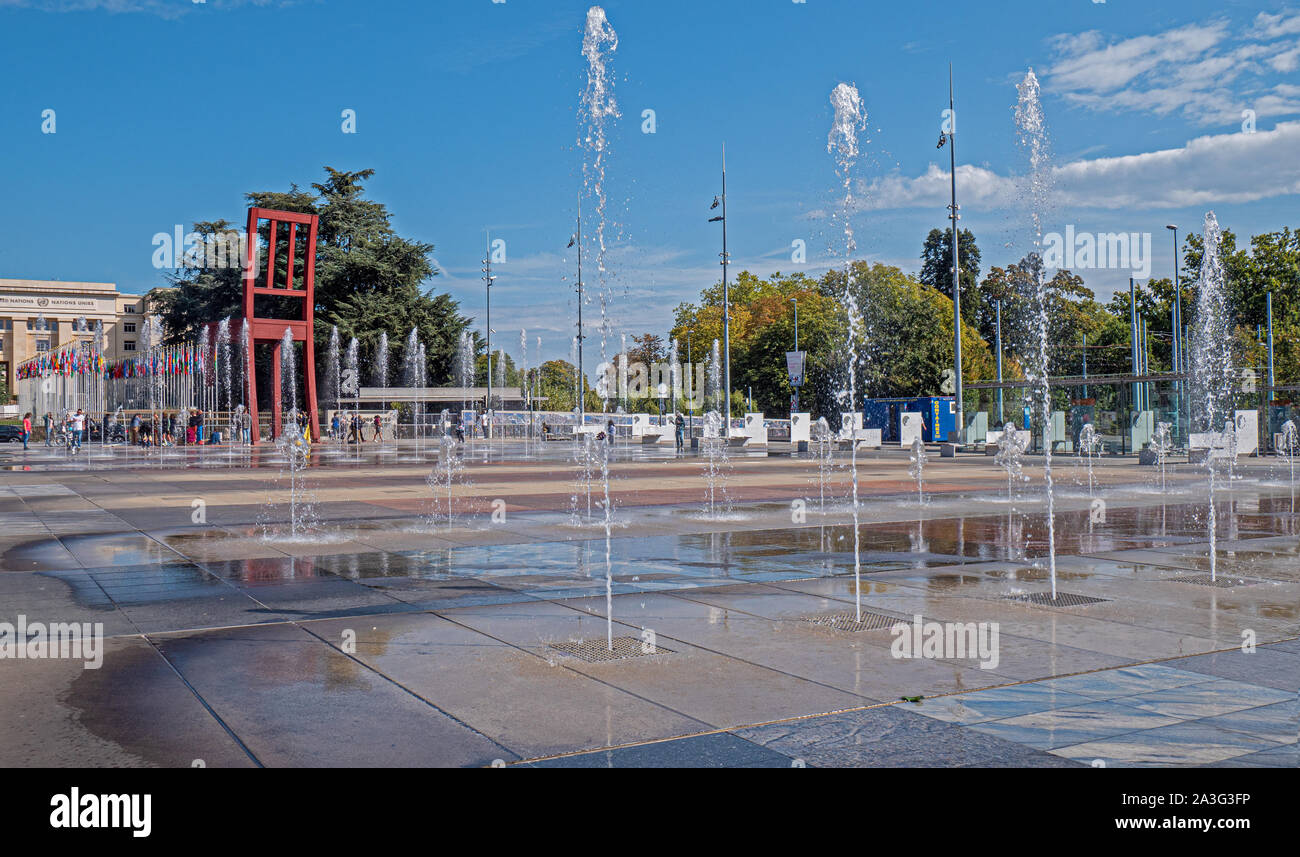 Ginevra, Svizzera - 22 Settembre 2019: l'acqua delle fontane e landmark sedia rotta scultura presso le Nazioni Unite gli edifici centrali a Ginevra, Svizzera. Foto Stock
