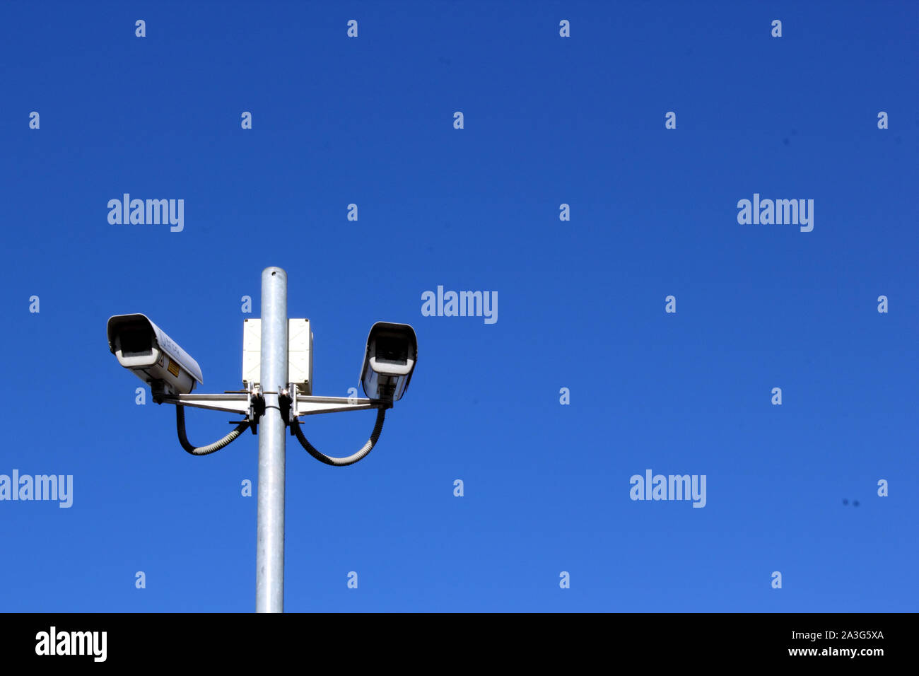 Vista del paesaggio di telecamere di sicurezza sul palo alto contro il profondo blu del cielo Foto Stock