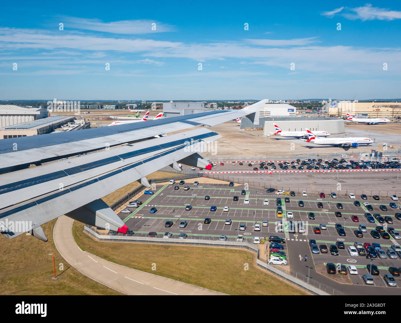 Vista dalla finestra del piano di sopra il parcheggio e hangar s sulla rotta di avvicinamento all'aeroporto di Heathrow di Londra, Inghilterra, Regno Unito Foto Stock
