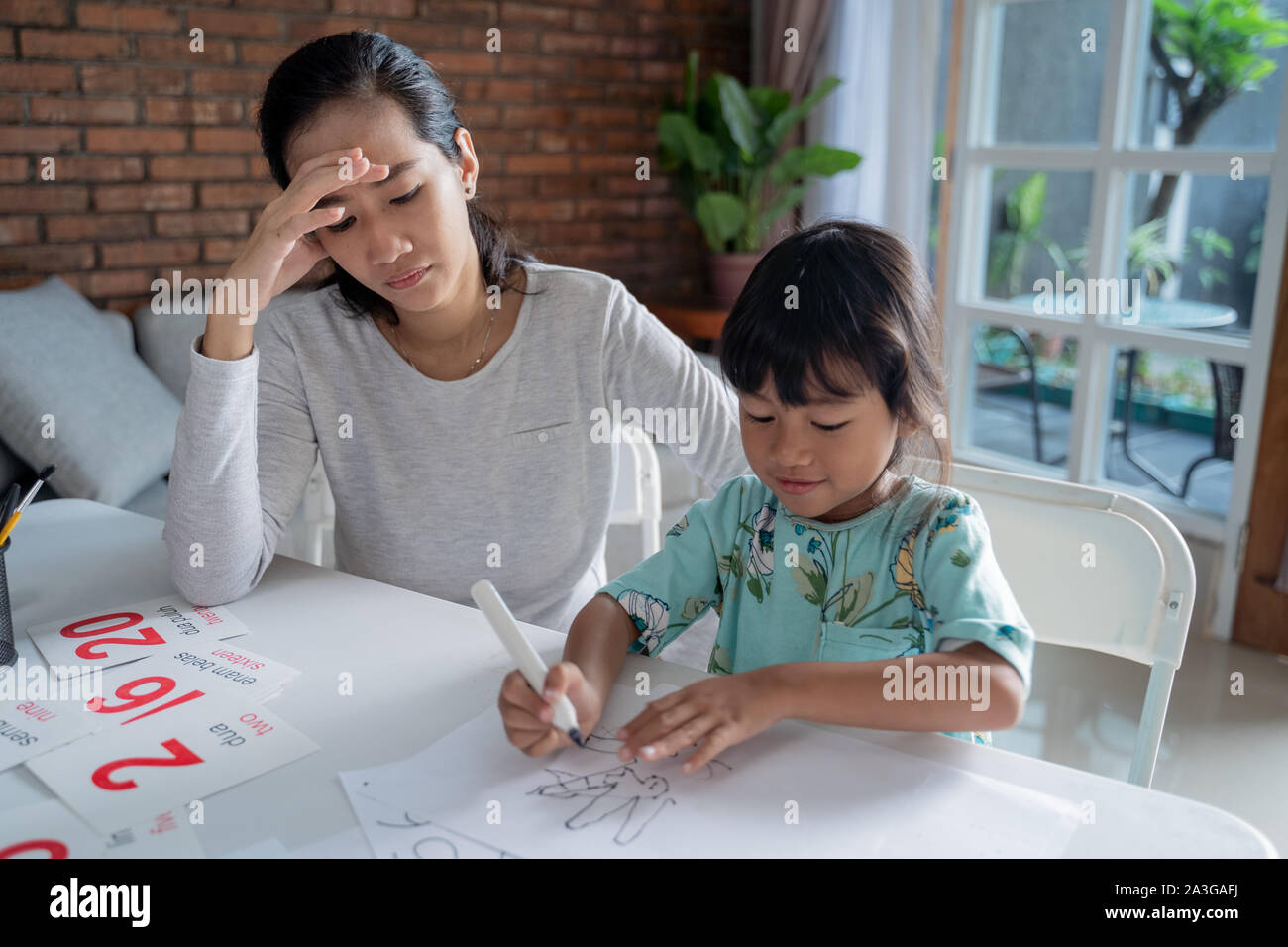 Ritratto di Madre infelice mentre insegnava la figlia a casa Foto Stock