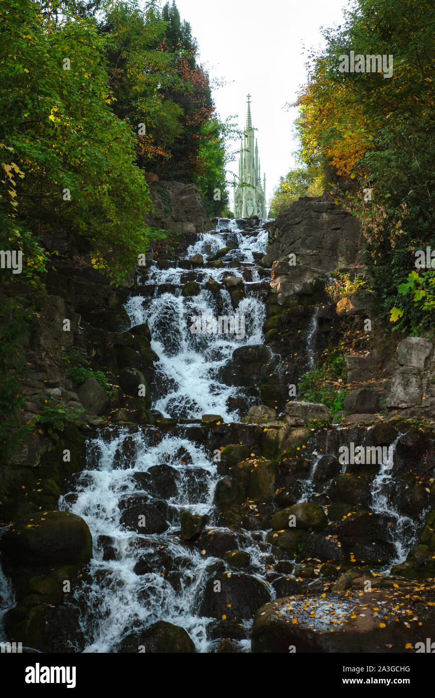 Corsi d'acqua fluenti, piscine lente e cascate pittoresche creano una tranquilla scena autunnale al Victoria Park, Berlino, Germania. Foto Stock