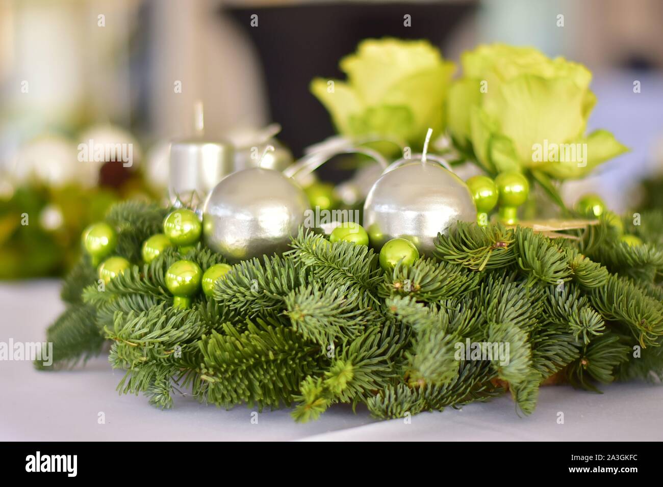 Corona di Avvento con argento candele sui rami di abete rosso con rose verde e verde palle di Natale Foto Stock