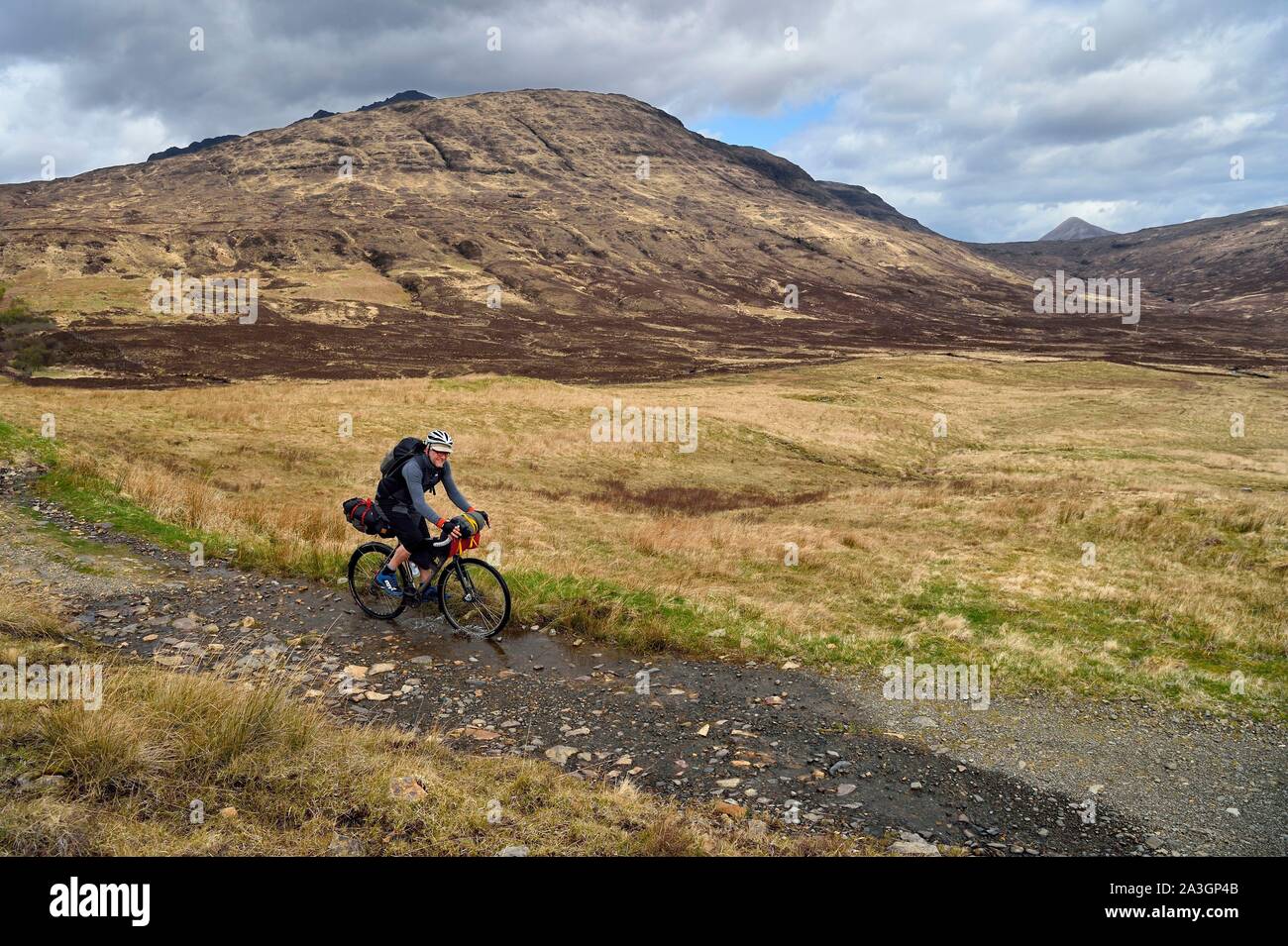 Regno Unito, Scozia, altopiani, Ebridi, Isola di Skye, mountain biker al nero montagne Cuillin sulla strada Camasunary Foto Stock