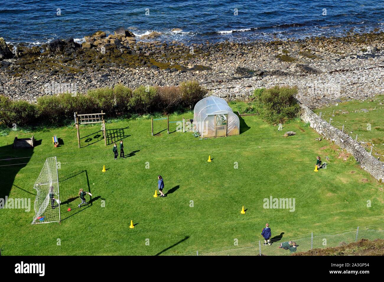 Regno Unito, Scozia, altopiani, Ebridi, Isola di Skye, Elgol villaggio sulle rive di Loch Scavaig verso la fine della penisola Strathaird, bambini che giocano macchine versatili nel giardino della scuola Foto Stock