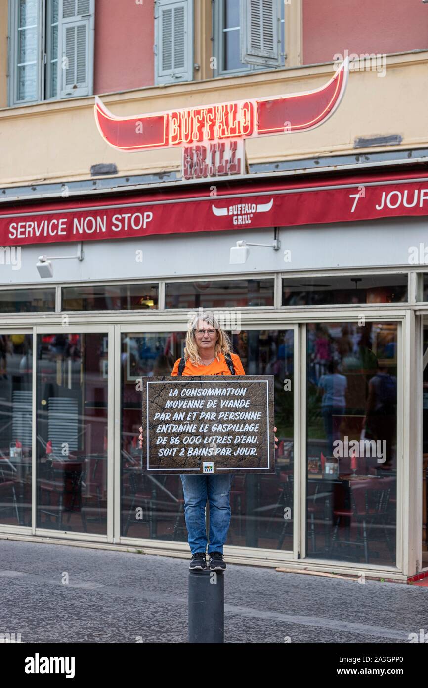 Francia, Var, Nizza, protester dal L214 Animal Welfare Association sventolare un segno con uno slogan contro il consumo eccessivo di carne di fronte a Buffalo Grill restaurant sign durante il mese di marzo per il clima di sabato 21 settembre, 2019 Foto Stock