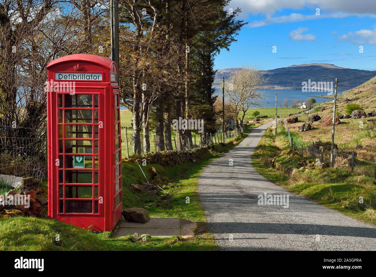 Regno Unito, Scozia, Highland, Ebridi Interne, Isle of Mull west coast, stretta strada costiera verso Balnahard, cabina telefonica convertito in un defibrillatore post Foto Stock